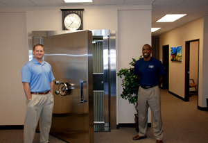 Kipp Bockhop, left, and former Denver Bronco Frank Robinson, two of the co-owners of Secure Cash Incorporation, display their huge vault at their Centennial business office